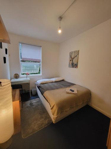 a bedroom with a bed and a desk and a window at Quiet Room Near Arsenal Stadium Islington Zone 2 Cental in London