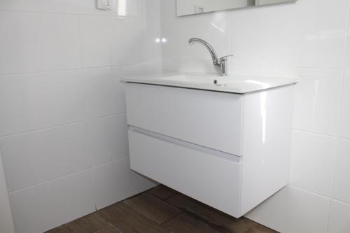a white kitchen with a sink and white walls at Beach Suite Israel- Private Jacuzzi Sea View Balcony, Off-Site Spa ביץ סוייט ישראל- ג'קוזי פרטי עם נוף ים, אפשרות לספא מוזל in Ashqelon