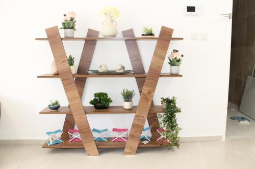 a wooden shelf with potted plants on it at Beach Suite Israel- Private Jacuzzi Sea View Balcony, Off-Site Spa ביץ סוייט ישראל- ג'קוזי פרטי עם נוף ים, אפשרות לספא מוזל in Ashqelon