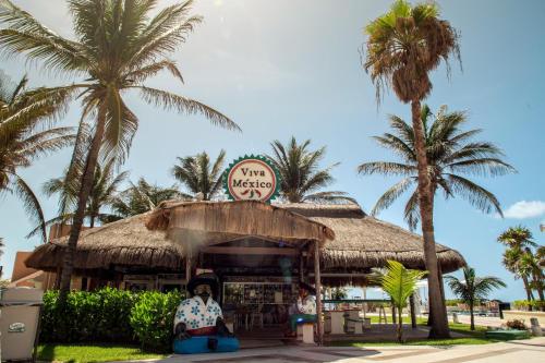 a restaurant on the beach with palm trees at Wyndham Grand Cancun All Inclusive Resort & Villas in Cancún