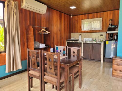 a kitchen with a wooden table and chairs at Cabañas Sueños del Arenal in Fortuna