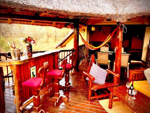 a room with chairs and a bar in a cabin at Majuli River House in Marloth Park