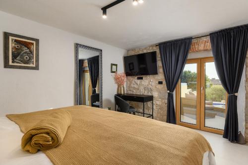 a bedroom with a bed and a tv and a window at Casa Mar in Mugeba