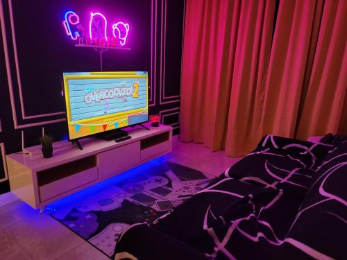 a room with a tv on a dresser with purple lights at The Ress - The Axon Bukit Bintang Residence in Kuala Lumpur