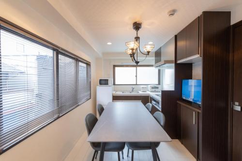 a kitchen with a table and chairs in a room at NAOMI - Self Check-In Only in Osaka