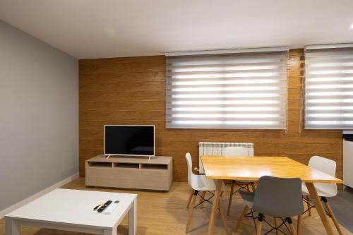 une salle à manger avec une table et une télévision dans l'établissement ALQUILAZ Apartamentos Turísticos, à Zamora