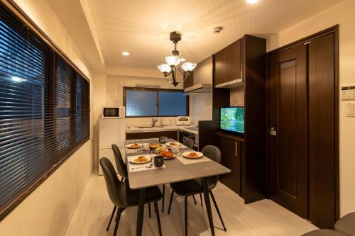 a kitchen with a table and chairs in a room at NAOMI - Self Check-In Only in Osaka