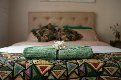 two green pillows sitting on top of a bed at Departamento en Mendoza Biznaga in Mendoza