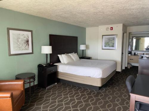 a hotel room with a bed and a chair at Quality Inn Clinton North in Clinton