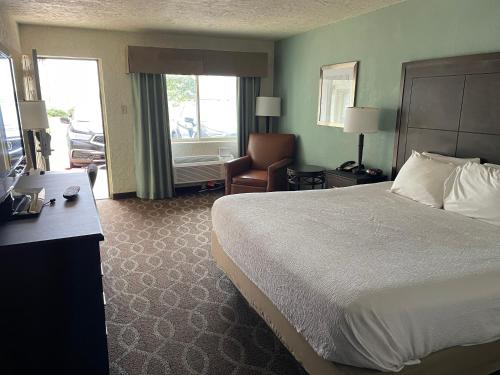 a hotel room with a bed and a chair at Quality Inn Clinton North in Clinton