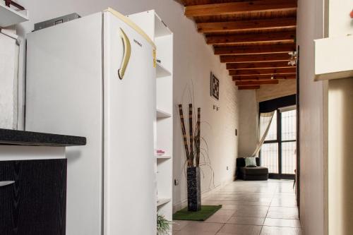 uma cozinha com paredes brancas e um tecto de madeira em Departamento en Mendoza Biznaga em Mendoza