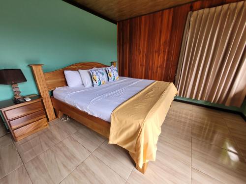 a bedroom with a bed and a lamp and a window at Cabañas Sueños del Arenal in Fortuna