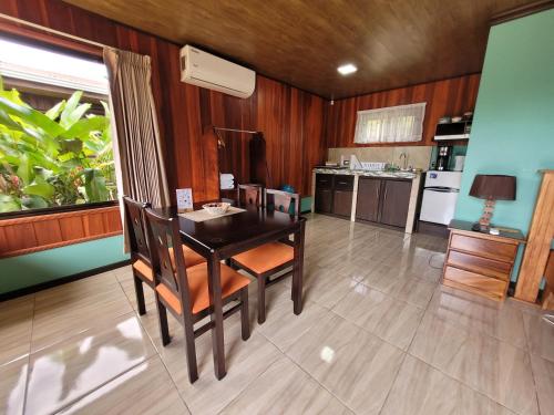a kitchen with a table and chairs in a room at Cabañas Sueños del Arenal in Fortuna