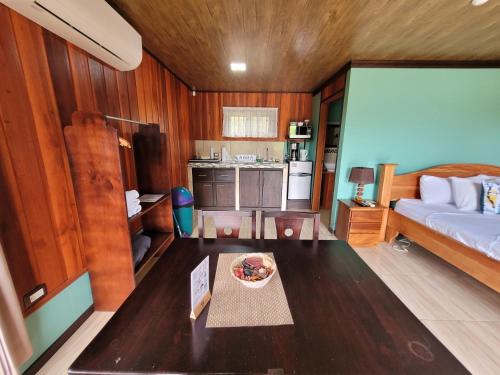 a living room with a bed and a table in a room at Cabañas Sueños del Arenal in Fortuna