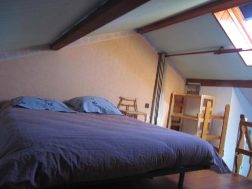 une chambre avec un lit avec des draps bleus et une fenêtre dans l'établissement location à la montagne, à Barcelonnette
