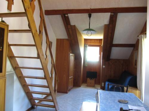 - un escalier en bois dans un salon avec une table dans l'établissement location à la montagne, à Barcelonnette