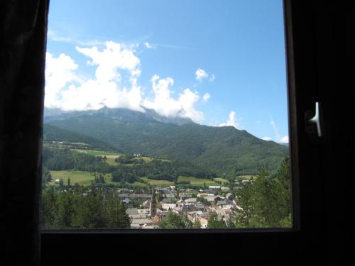 Elle offre une vue sur la montagne depuis sa fenêtre. dans l'établissement location à la montagne, à Barcelonnette