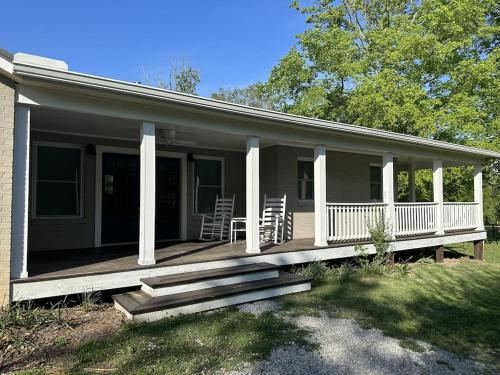 una casa con un portico con sedie sopra di The Cottage at Broad Hill Run Farm a Lenoir City