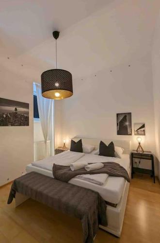 a bedroom with a large bed and a pendant light at Luxury CityApartment 7 in Vienna