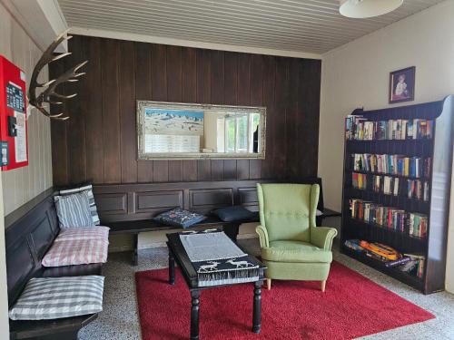 a living room with a couch and a book shelf at Gerlitzen-Apartments in Kanzelhöhe