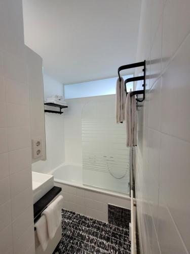 a white bathroom with a shower and a tub at Gerlitzen-Apartments in Kanzelhöhe