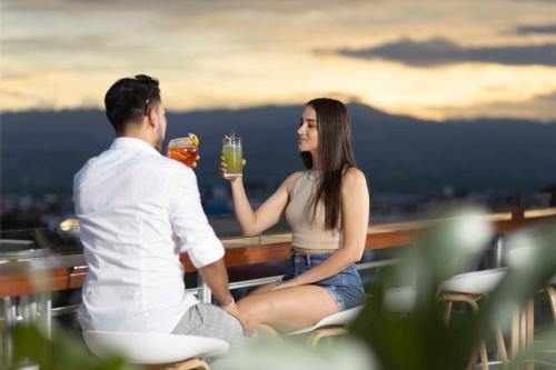 a man and woman sitting on a balcony with drinks at Rio Cumbaza Hotel in Tarapoto