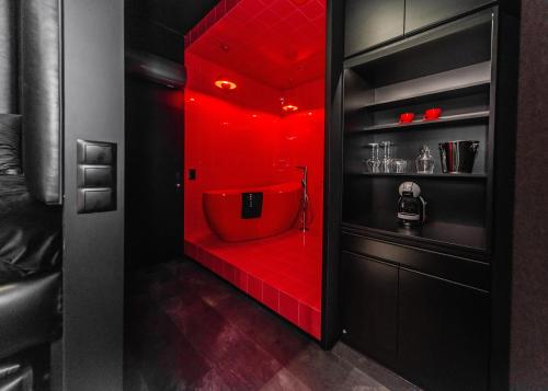 ein rotes Bad mit einer roten Badewanne in einem Zimmer in der Unterkunft Eclipse Red Room in Bielsko-Biała