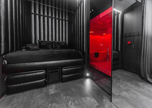 Schlafzimmer mit schwarzem Bett und roter Beleuchtung in der Unterkunft Eclipse Red Room in Bielsko-Biała