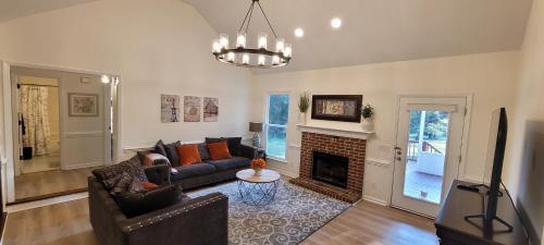 a living room with a couch and a fireplace at Meadow Farm in Holly Springs, NC in Holly Springs