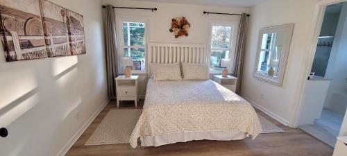 a bedroom with a bed and two windows at Meadow Farm in Holly Springs, NC in Holly Springs