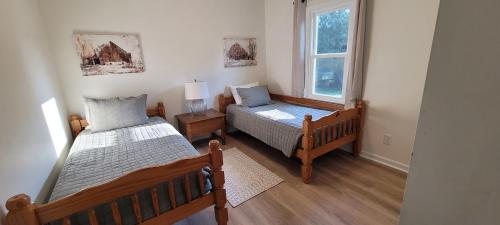 1 dormitorio con 2 camas y ventana en Meadow Farm in Holly Springs, NC, en Holly Springs