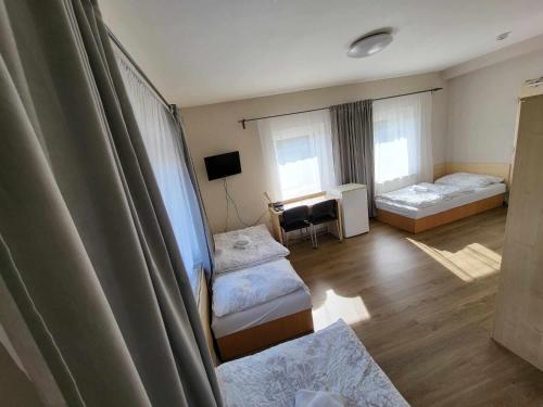 Habitación con 2 camas y escritorio. en Restaurace a penzion Vrtule, en Petřvald