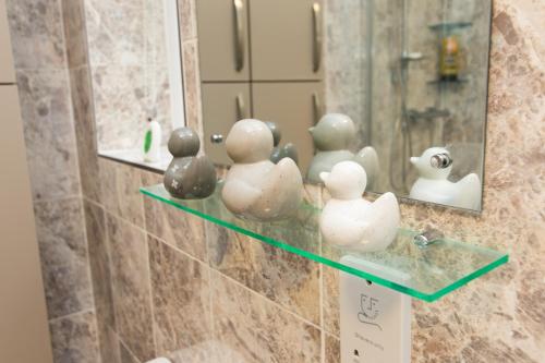 a bathroom with a shelf with rubber figurines on it at Newly Renovated Perfect Family Home in Nottingham in Nottingham