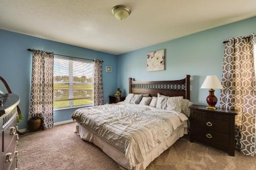 a bedroom with a bed with blue walls and a window at Sunny Wesley Chapel Home about 2 Mi to Epperson Lagoon in Wesley Chapel