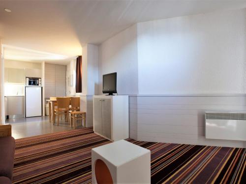 un salon avec une cuisine et un salon avec un canapé dans l'établissement Appartement confortable 2 pièces avec balcon, départ skis aux pieds, Wifi inclus - FR-1-314-213, à Morzine