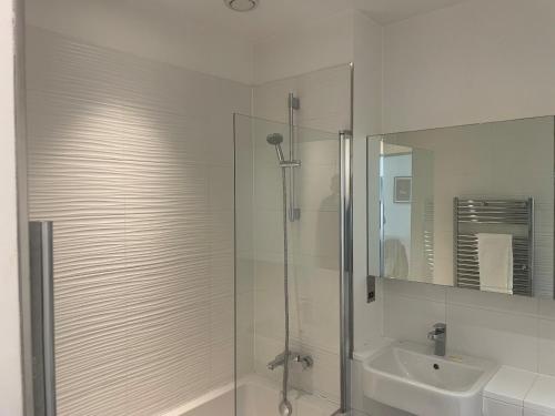 a white bathroom with a shower and a sink at Bracknell Stunning 2 Bedroom and 2 Bathroom Apartment in Bracknell