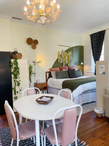 a bedroom with a bed and a white table and chairs at Romantic 1885 Loft Steps from Pulaski Square in Savannah