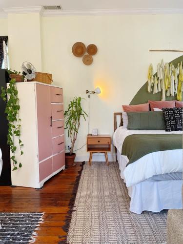 um quarto com uma cama e uma cómoda rosa em 1885 Vintage Parlor Loft: Heart of Historic SAV em Savannah