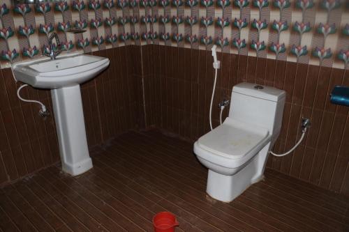 a bathroom with a toilet and a sink at Kalika Hill Resort in Barkot