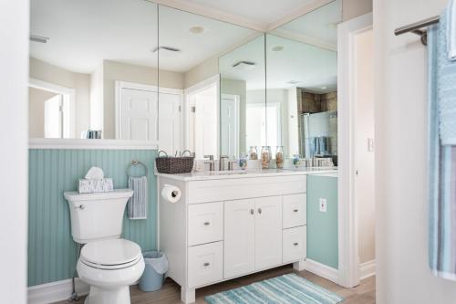 a bathroom with a toilet and a large mirror at Beachside 109 with Direct Beach Access Pool and Hot Tub in Traverse City