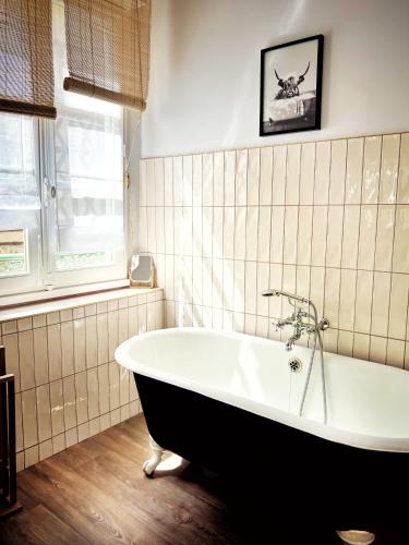 a bath tub in a bathroom with a window at Maison d'hôte Les Allois in Limoges