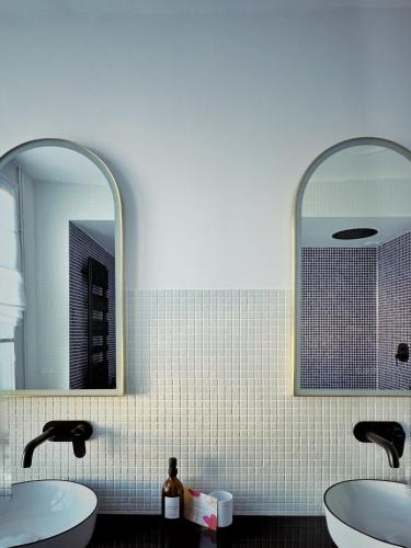 a bathroom with two sinks and two mirrors at Maison d'hôte Les Allois in Limoges