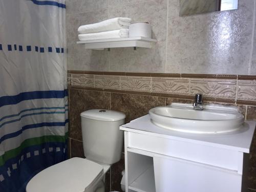 y baño con lavabo blanco y aseo. en The Mendoza Grand Hotel, en Barranquilla
