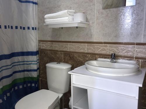a bathroom with a white sink and a toilet at The Mendoza Grand Hotel in Barranquilla