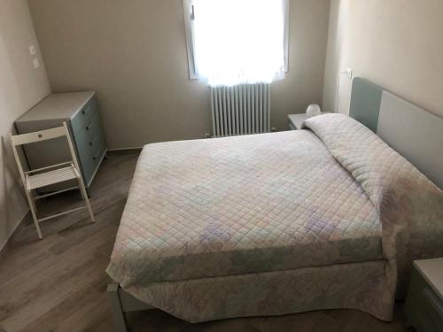 een slaapkamer met een bed, een dressoir en een raam bij Colomba Apartment in Tolè