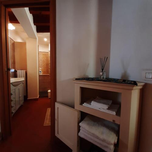 a bathroom with a sink and a shelf with towels at Loft trabucco panoramico 4 camere 7posti letto vista lago e centro storico in Salò