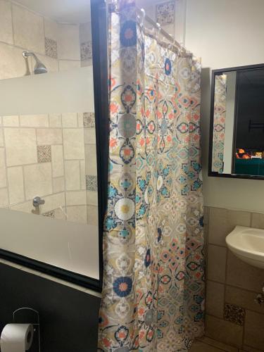 a shower curtain in a bathroom with a sink at Casa privada, ubicada cerca del centro histórico de Santa Ana in Santa Ana