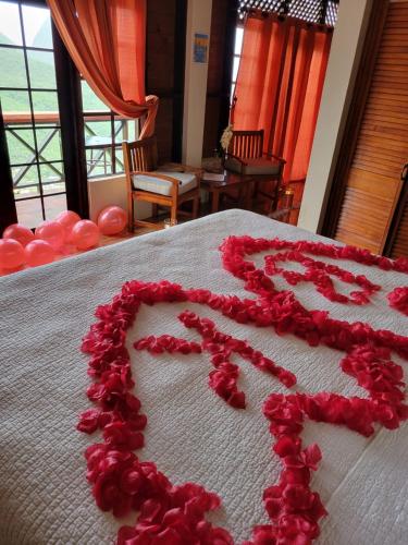 a heart made out of red flowers on a bed at Samfi Gardens in Soufrière