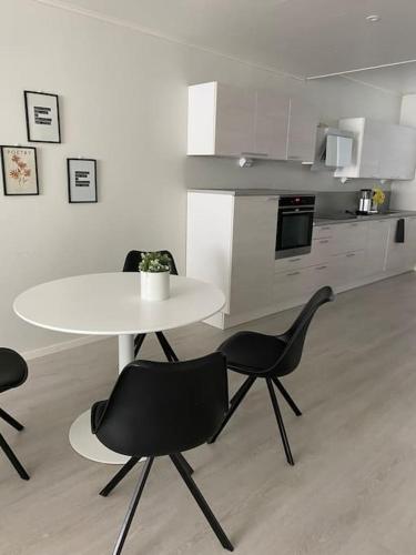 een tafel en stoelen in een kamer met een keuken bij Täysin remontoitu iso kaksio. in Rauma