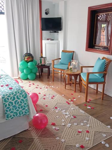 a living room with a bed and a table with balloons at Samfi Gardens in Soufrière